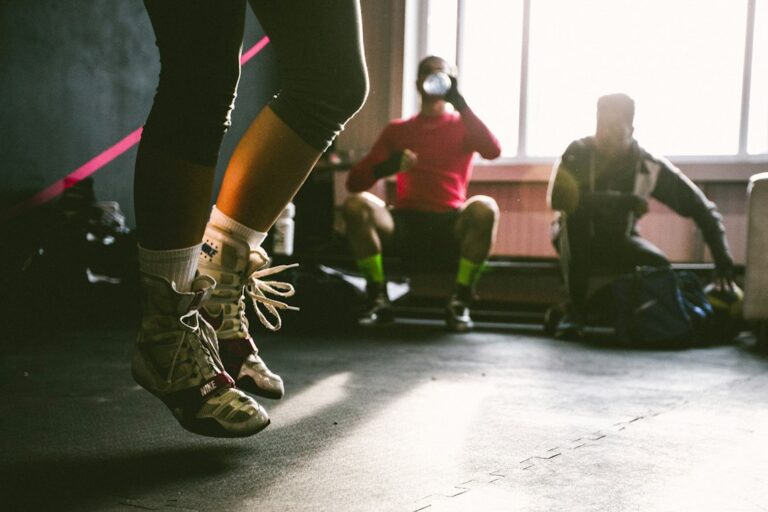 Adults briskly walk outdoors while another person performs resistance-band exercises at home.